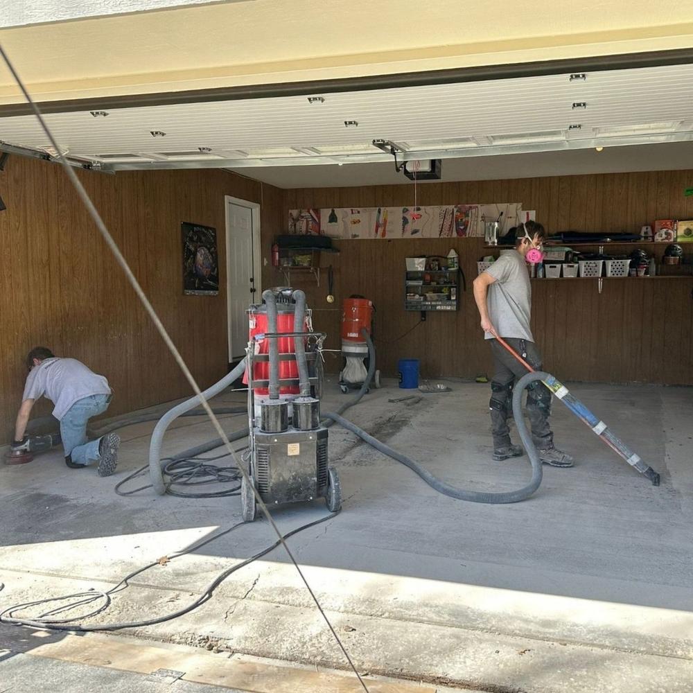 Crew diamond grinding a garage floor with industrial equipment