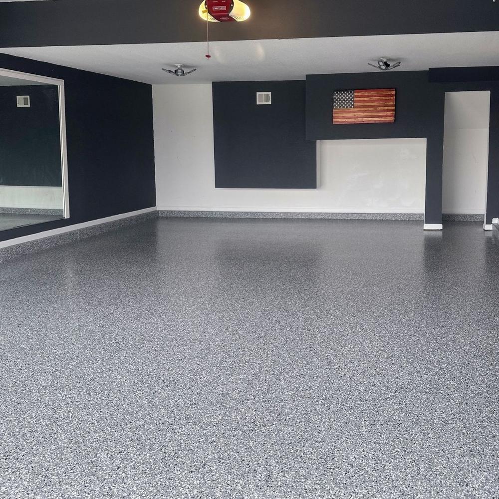 Stylish garage with dark walls, American flag art, and epoxy floor